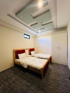 ein Schlafzimmer mit zwei Betten in einem Zimmer in der Unterkunft Fialong Hotel Skardu in Skardu