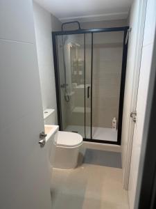 a bathroom with a toilet and a glass shower at Jupiter 4 dormitorios 300 depósito in Alcorcón