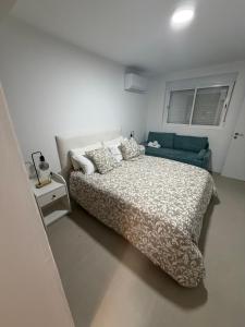 a white bedroom with a bed and a couch at Jupiter 4 dormitorios 300 depósito in Alcorcón