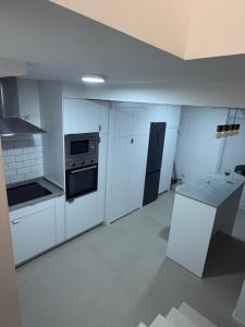 a kitchen with white cabinets and a stove top oven at Jupiter 4 dormitorios 300 depósito in Alcorcón