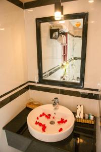 a bathroom with a sink with red flowers on it at Viva Beach Resort Mui Ne in Mui Ne