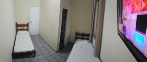 a room with two beds and a tv on the wall at Estação Pousada e Hostel in Cataguases +10 photos