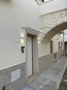 a white building with a white door and a wall at Buonaventura house2 in Triggiano