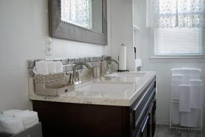 a white bathroom with a sink and a mirror at Eden's Cozy Oasis in Windsor +44 photos