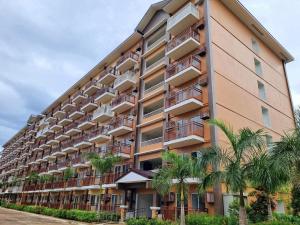 a tall building with palm trees in front of it at B1 4Magnificent in Puerto Princesa City