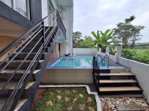 a swimming pool next to a house with a staircase at Villa SOORYAALI in Galle