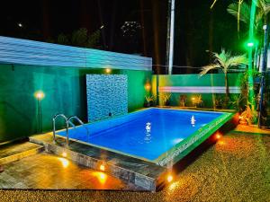 a swimming pool at night with lights around it at Shehan villa in Beruwala