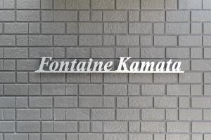 a brick wall with a street sign on it at Fontaine Kamata by Tranova in Tokyo +62 photos
