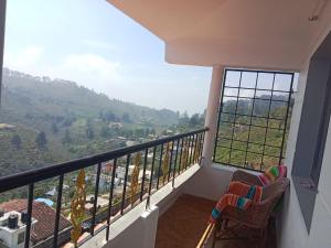 a balcony with two chairs and a view of a mountain at AFIYA HOME STAy in Kodaikānāl