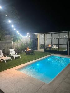 a backyard with a swimming pool at night at Quincho cervecero in San Fernando del Valle de Catamarca