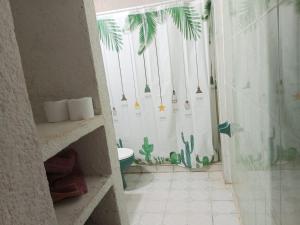 a bathroom with a shower with a cactus shower curtain at Casa luci in Zipolite