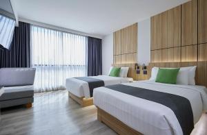 a hotel room with two beds and a chair at The Four Wings Hotel Bangkok in Bangkok +48 photos