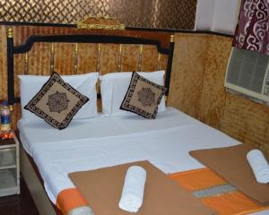 a bed with two pillows and a laptop on it at amb guest house in Chennai