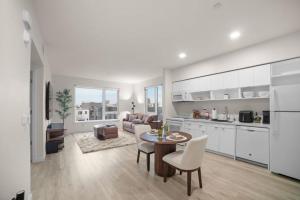 a kitchen and a living room with a table and chairs at Modern Lux Midrise Stadium & Downtown Views in West Sacramento