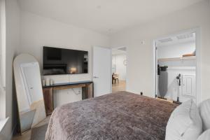 a bedroom with a large bed and a tv at Modern Lux Midrise Stadium & Downtown Views in West Sacramento