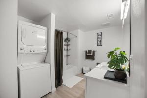 a white bathroom with a toilet and a sink at Modern Lux Midrise Stadium & Downtown Views in West Sacramento +1 photo