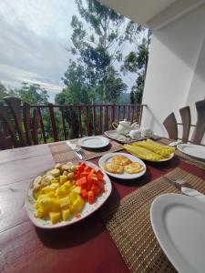 a table with plates of fruit on top of it at Eco Diamond Palace in Ella +58 photos