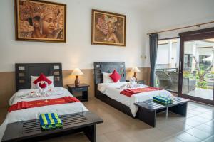 a hotel room with two beds and a balcony at Tulamben Dive Resort in Tulamben