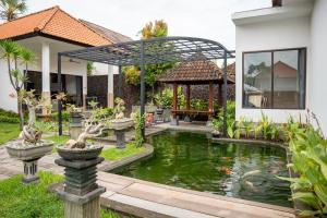 a garden with a pond and a gazebo at Tulamben Dive Resort in Tulamben