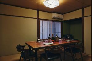 a room with a wooden table with wine bottles and chairs at 白金はなれ in Susakiuramachi +50 photos