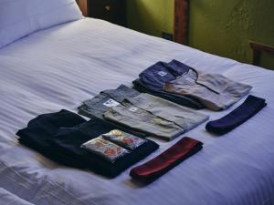 a pile of clothes sitting on top of a bed at 白金はなれ in Susakiuramachi