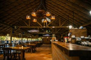 a restaurant with wooden tables and chairs and lights at Refugio Natural - Guarne - Cabañas Ecológicas con Jacuzzi e hidromasaje in Guarne