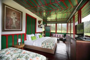 a bedroom with two beds and a television in it at Finca La Playa Ecohotel - Experiencia Campestre - in Salento