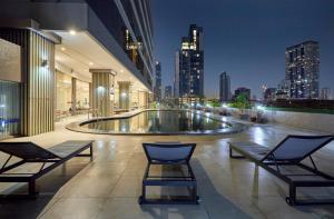 a building with two chairs and a pool at night at The Four Wings Hotel Bangkok in Bangkok
