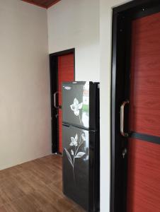 a black refrigerator with flowers painted on it in a room at Traveling Guest House - Shared Kitchen in Kuta Lombok +28 photos