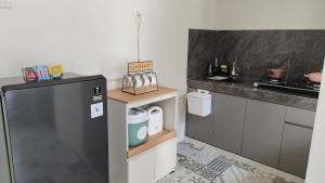 a kitchen with a black refrigerator and a counter at patangpuluh homestay in Purwokerto