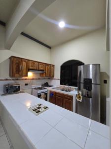 a kitchen with wooden cabinets and a stainless steel refrigerator at The Stone Way Suite in Juayúa