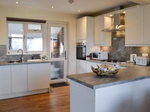 a kitchen with white cabinets and a counter top at Glencairn Rd in Langbank