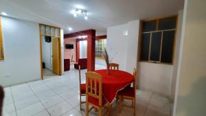 a living room with a red table and chairs at Departamento jaspe in Cajamarca
