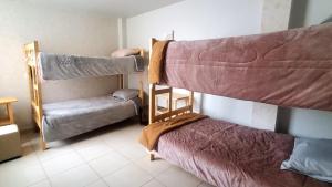 a room with two bunk beds and a couch at Departamento jaspe in Cajamarca
