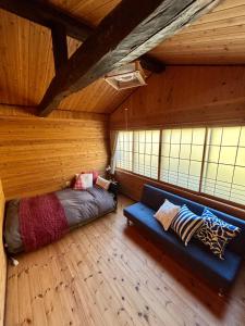 a bedroom with a bed and a couch in a room at 田舎の別荘 かすみ草 in Shōgahora