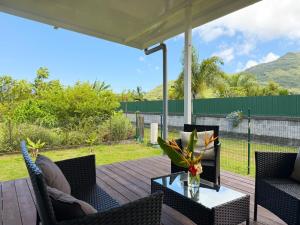 a patio with chairs and a table on a deck at Quiet house - great mountain view in Tiaraha