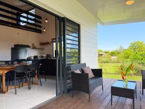 a patio with a table and chairs and a kitchen at Quiet house - great mountain view in Tiaraha