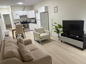 a living room with a couch and a flat screen tv at Cozy Home in Surrey