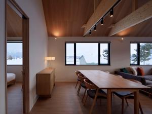 a room with a table and chairs and a couch at Villa Matsu by H2 Life in Nakafurano