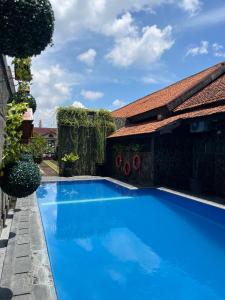 a large blue swimming pool next to a building at Candra Dewi Yogyakarta in Yogyakarta