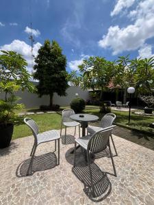 a patio with three chairs and a table and a table at Candra Dewi Yogyakarta in Yogyakarta