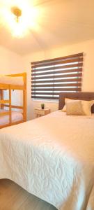 a bedroom with a large white bed with a window at Cabañas Torres del Sol in Vicuña +20 photos