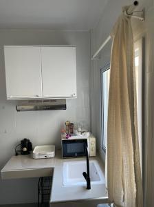 a small kitchen with a sink and a window at Butterfly Home Mai Khao Phuket in Ban Suan Maphrao