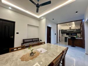 a dining room with a table and a kitchen at Nana's Residency, Cochin in Alwaye +14 photos