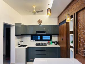 a kitchen with black and white appliances and a ceiling at Nana's Residency, Cochin in Alwaye