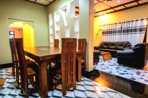 a living room with a wooden table and a couch at Villa in Kalviyankadu in Irupalai