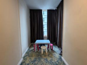 a table and two chairs in a room with a window at Asto Hotel Kuala Lumpur in Kuala Lumpur