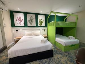 two beds in a room with green and white at Asto Hotel Kuala Lumpur in Kuala Lumpur