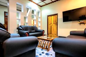 a living room with chairs and a tv and a table at Villa in Kalviyankadu in Irupalai
