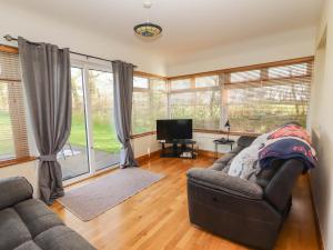 a living room with a couch and a television at Moybella Lodge in Ballybunion